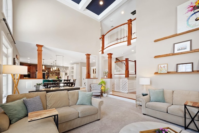 living room with light carpet, decorative columns, a towering ceiling, and beam ceiling