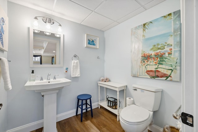 bathroom with toilet, sink, a paneled ceiling, and wood-type flooring