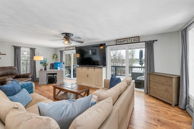 living room with light wood-type flooring, ceiling fan, and plenty of natural light