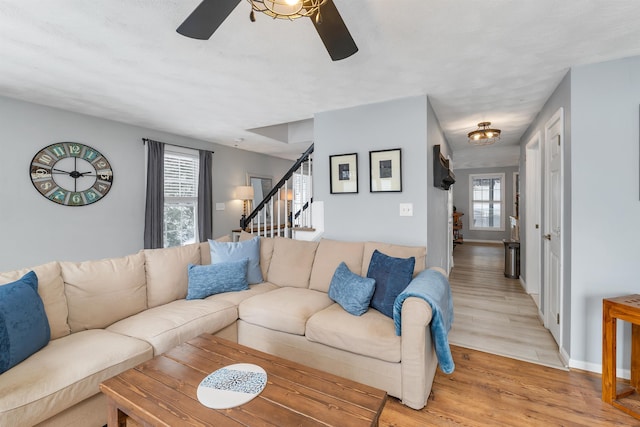 living room with light hardwood / wood-style floors and ceiling fan