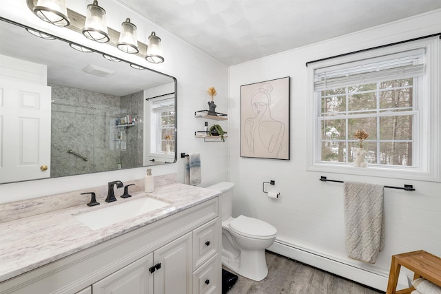 bathroom with plenty of natural light, a baseboard heating unit, hardwood / wood-style flooring, and walk in shower