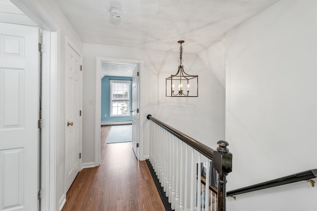 corridor with a baseboard heating unit and dark wood-type flooring