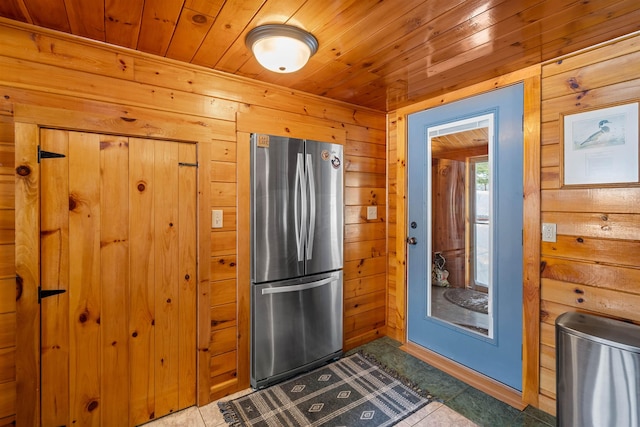 kitchen with wood ceiling, wood walls, and freestanding refrigerator