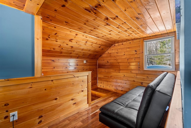 sitting room with lofted ceiling, wood finished floors, wood ceiling, and wooden walls