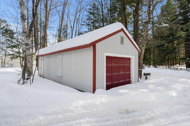 snow covered garage featuring a garage