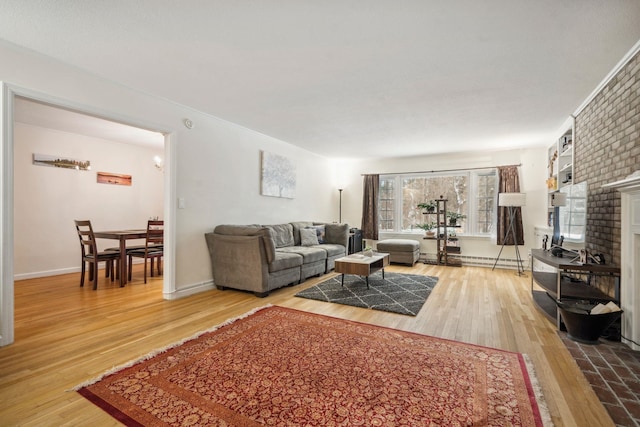 living room featuring a baseboard heating unit, a brick fireplace, and wood-type flooring