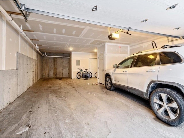 garage with electric panel and a garage door opener