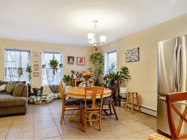 tiled dining space featuring a baseboard radiator, an inviting chandelier, and plenty of natural light