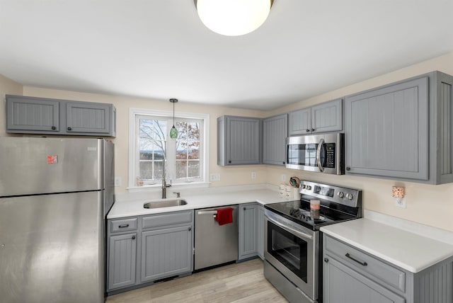 kitchen featuring hanging light fixtures, appliances with stainless steel finishes, and gray cabinetry