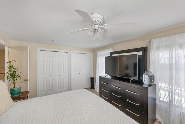 bedroom featuring ceiling fan and multiple closets