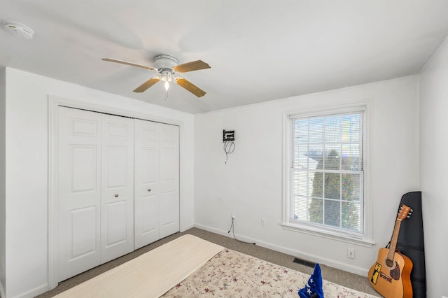 carpeted bedroom featuring a closet and ceiling fan