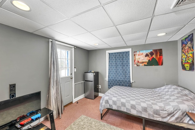 carpeted bedroom featuring a drop ceiling