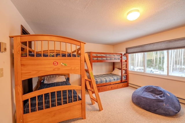 carpeted bedroom featuring a baseboard heating unit and a textured ceiling