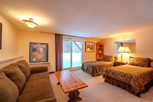 carpeted bedroom with access to outside and a textured ceiling