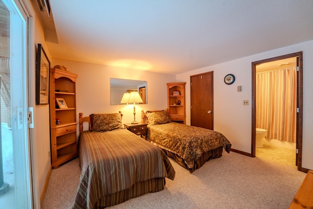 bedroom featuring light carpet and ensuite bath