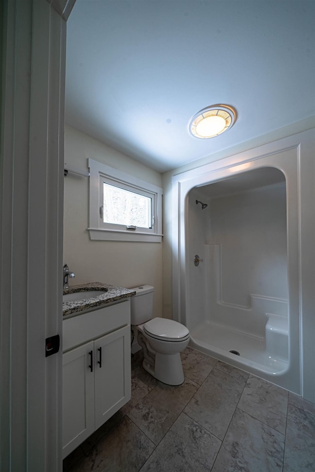 bathroom featuring toilet, vanity, and walk in shower