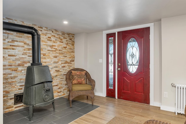 entryway with radiator heating unit and a wood stove