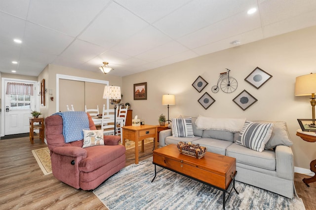 living room with a drop ceiling and hardwood / wood-style floors