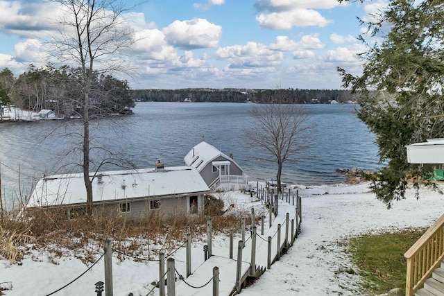 yard layered in snow featuring a water view