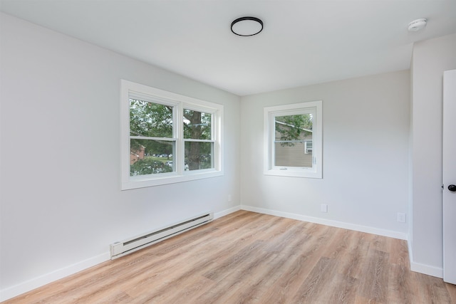 empty room featuring a baseboard radiator and light wood-type flooring