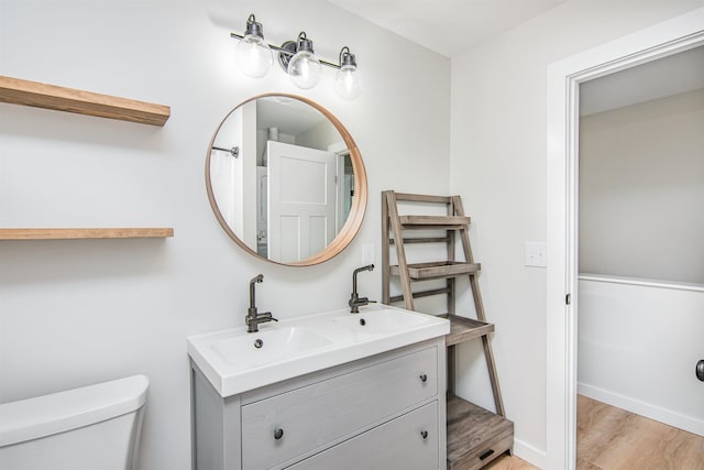 bathroom featuring toilet, hardwood / wood-style flooring, and vanity