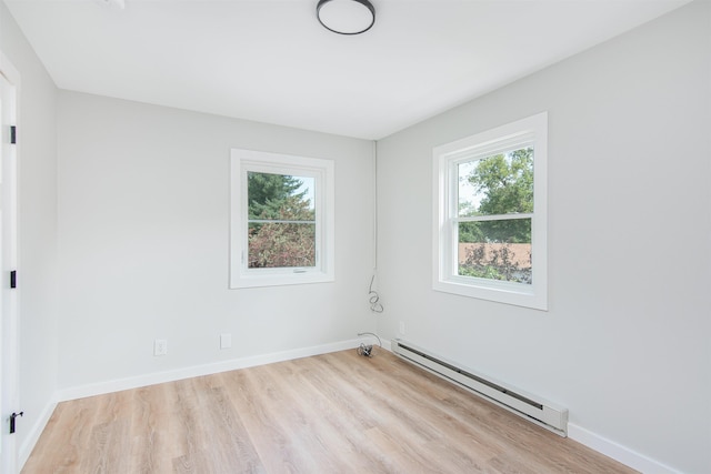 empty room featuring baseboard heating and light wood-type flooring