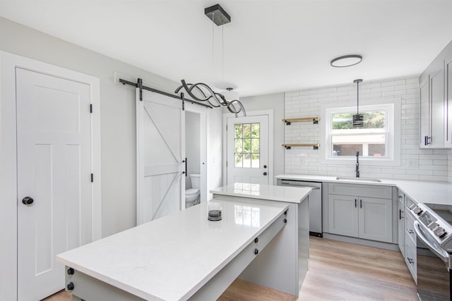 kitchen featuring pendant lighting, sink, a kitchen island, and a barn door