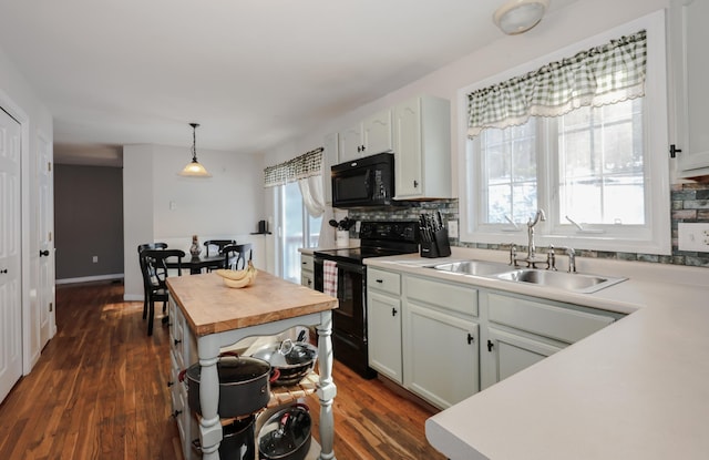 kitchen with butcher block counters, black appliances, pendant lighting, sink, and white cabinetry