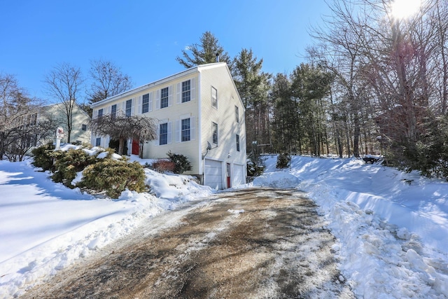 view of snow covered exterior featuring a garage