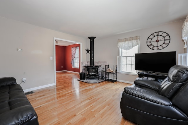 living room featuring hardwood / wood-style flooring and a wood stove