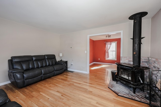 living room featuring a wood stove and light hardwood / wood-style flooring