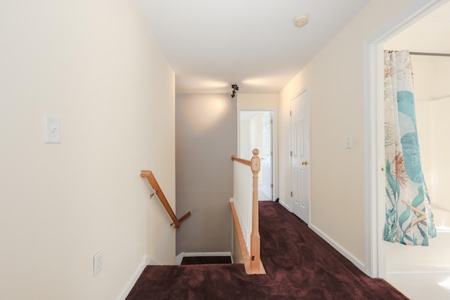 corridor featuring dark colored carpet