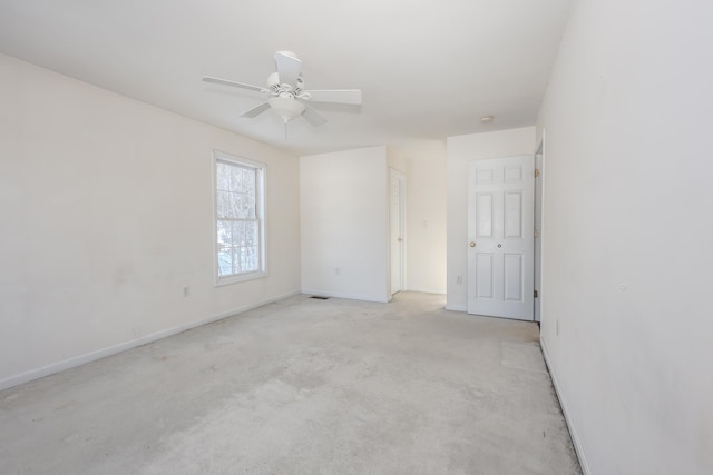 carpeted spare room featuring ceiling fan