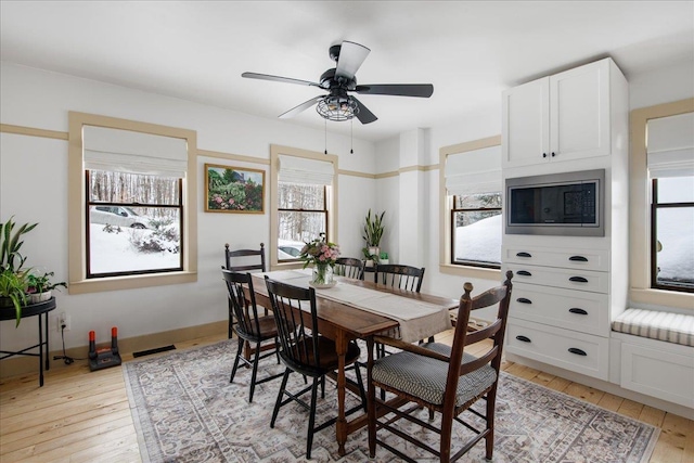 dining room with light hardwood / wood-style floors and ceiling fan