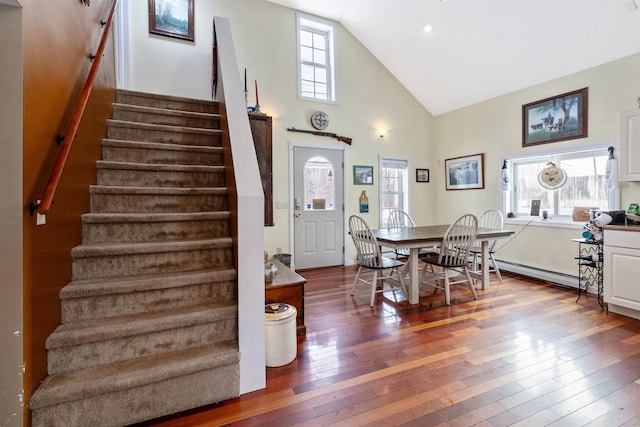 dining room featuring high vaulted ceiling, baseboard heating, and wood-type flooring