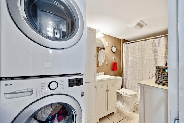 clothes washing area with sink, stacked washer and clothes dryer, and light tile patterned floors