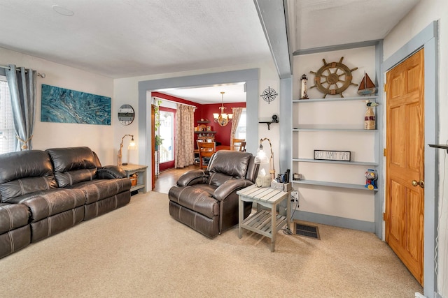 carpeted living room with a chandelier