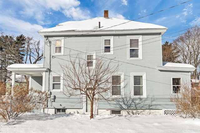 view of snow covered rear of property