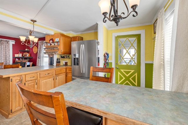 kitchen featuring kitchen peninsula, stainless steel fridge with ice dispenser, an inviting chandelier, plenty of natural light, and pendant lighting