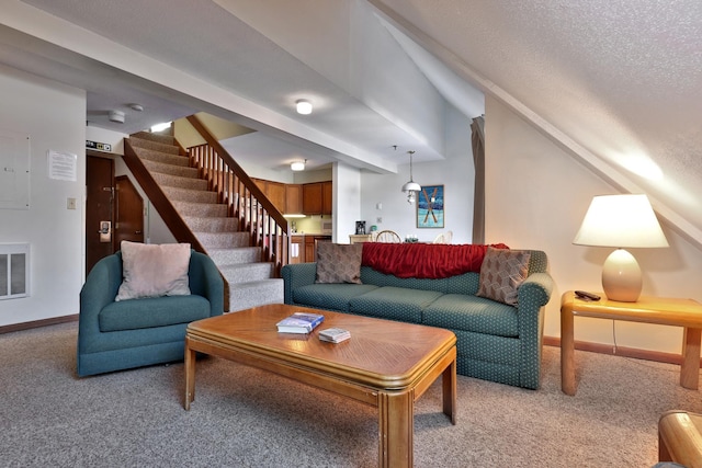 living room with beamed ceiling, a textured ceiling, and light colored carpet