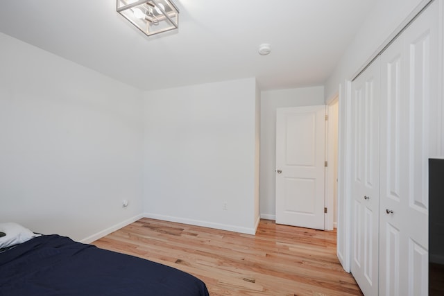 unfurnished bedroom with light hardwood / wood-style flooring and a closet