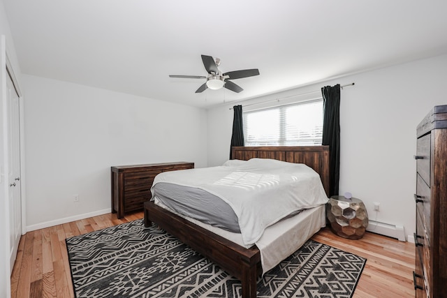 bedroom with ceiling fan, a closet, light hardwood / wood-style floors, and baseboard heating