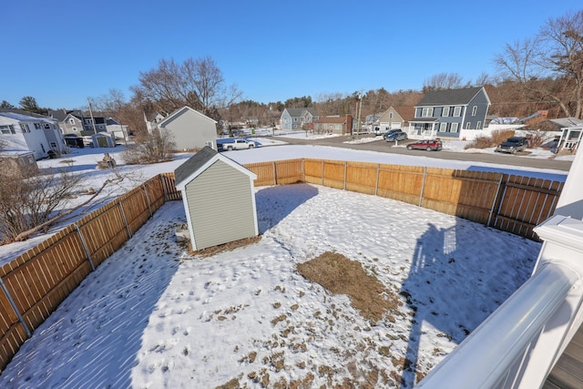 yard layered in snow with a storage unit