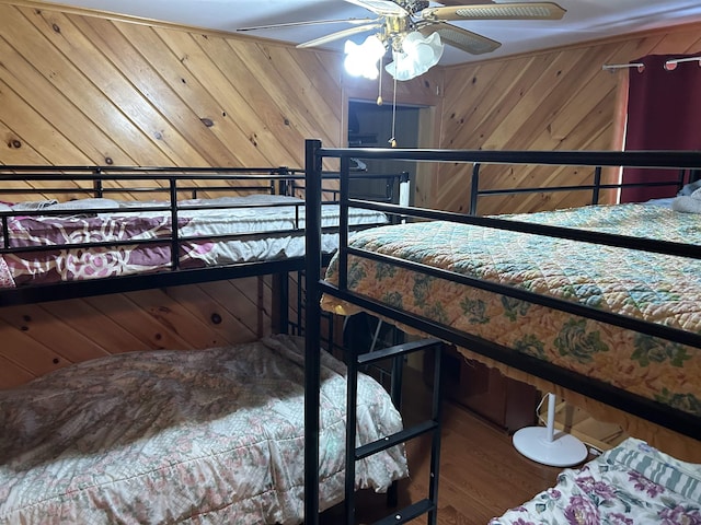 bedroom with wood walls and wood finished floors