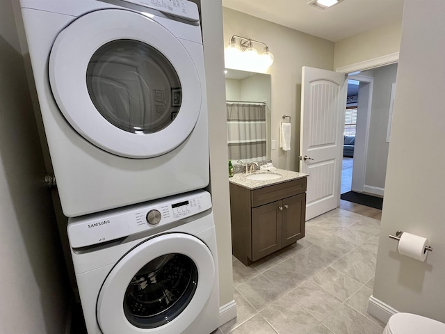 laundry area featuring sink and stacked washer and clothes dryer