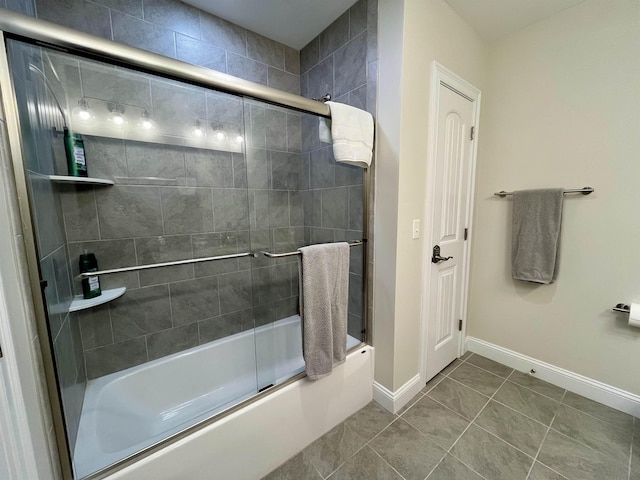 bathroom featuring tile patterned flooring and bath / shower combo with glass door