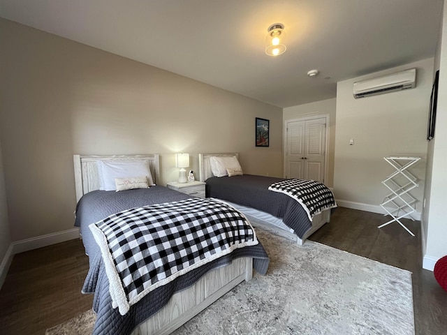 bedroom featuring a wall unit AC and dark wood-type flooring