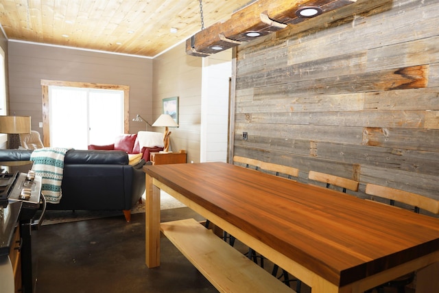 dining space featuring wooden walls and wooden ceiling