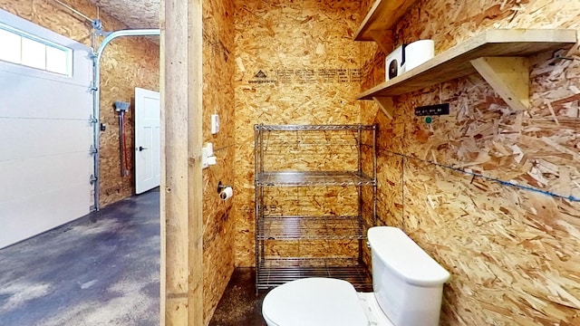 bathroom with concrete flooring and toilet