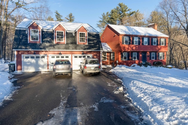 view of front of house featuring roof with shingles, aphalt driveway, and a chimney